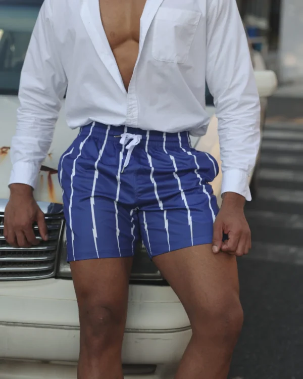 men wearing navy pinstripe mesh shorts wholesale with open white shirt leaning against vintage car